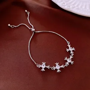 Silver bolo bracelet with zircon cross star charms on dark red silk background