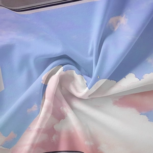 Close-up of silk fabric with romantic blue and pink cloud print in spiral drape
