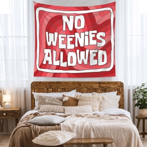 Close-up of bohemian red tapestry with white slogan hanging above a bed in bedroom