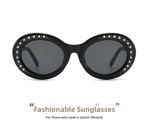 Close-up of oval black sunglasses with sparkling rhinestones and dark grey lenses