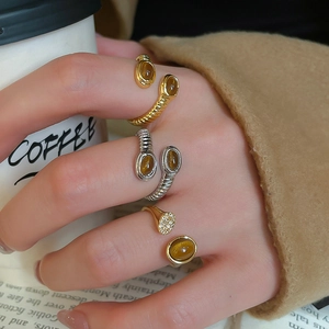 Detail shot of vintage crossover ring with oval amber stone and gold textured metal band