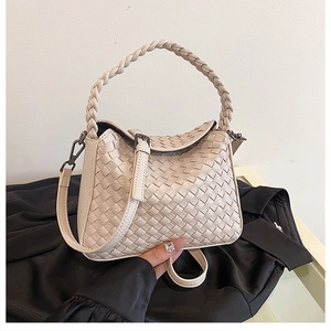 Detailed view of beige hand-woven leather handbag with classic checkered weave pattern