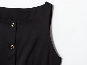 Detail of a black sleeveless top featuring gold metal buttons and premium cotton texture