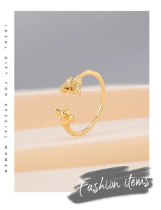Macro view of adjustable gold-plated ring featuring butterfly and honeybee detailing