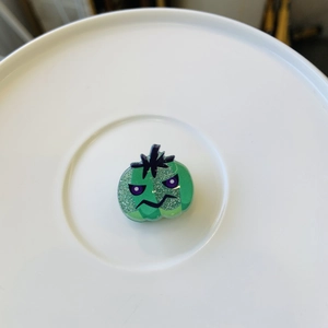 Detail of green glitter Halloween ghost hair clip with purple eyes and funny face