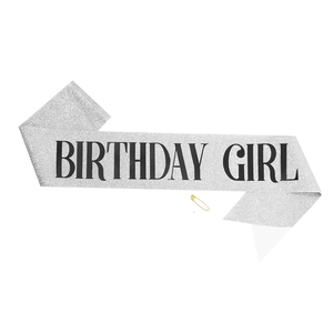 Detail of silver glitter Birthday Girl sash with black lettering and golden safety pin