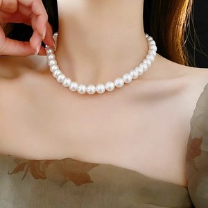 Gros plan d'un collier de perles élégant porté par un mannequin pour un look style français