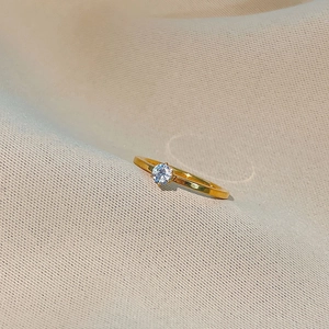 Minimalist gold titanium steel ring with brilliant round zircon in a classic 4-prong setting