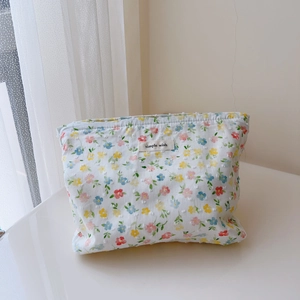 Detailed close-up of small floral print fabric and simple wish tag on cotton cosmetic bag