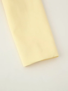 Gros plan sur la manche du blazer jaune pâle montrant la texture du tissu sergé fin