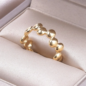 Detailed view of a gold-plated beaded bubble ring displayed in a luxury velvet jewelry box