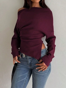 Detail of dark purple off-shoulder knit sweater featuring a side slit waist design