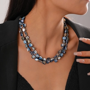 Detailed close-up of double-layer beaded necklace with dark abalone shell texture