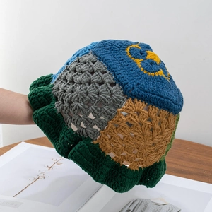 Detailed view of handmade crochet floral pattern and texture on knit bucket hat