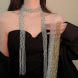 Detailed view of long beaded tassel scarf necklace in silver and gold mesh design.