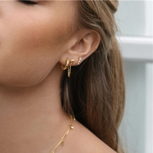 Close-up of gold star earrings and leaf pendant necklace set on a female model