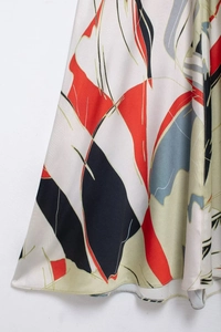 Detail of elegant satin dress showing abstract geometric prints and silky fabric texture