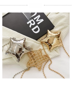 Three star-shaped mini bags in gold and silver finishes with ball chain straps