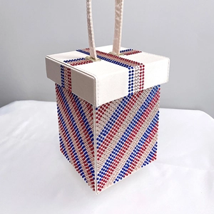 Detailed view of rhinestone evening bag with red and blue stripes and crystal handles