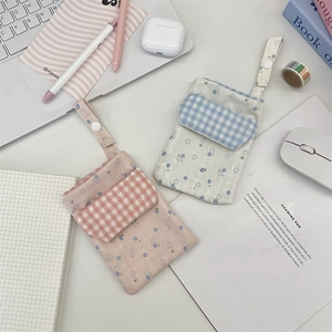 Detail of floral and plaid nurse pen pouches with button closure on a desk setup