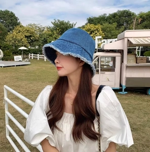 Détail du chapeau cloche en denim avec bords effilochés et texture vintage