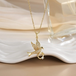 Elegant gold-plated bird pendant necklace with sparkling cubic zirconia on wavy tray