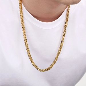 Macro close-up of a gold Byzantine chain link bracelet on a male model's wrist