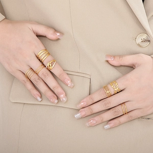 Detail of adjustable gold-tone leaf rings and stacked crystal bands on model hands