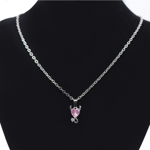 Pink heart crystal devil necklace with silver horns and zircon tail on black bust display