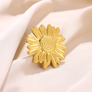 Golden daisy flower ring with sun flower petals on white soft satin background