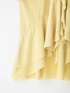 Detail of layered ruffles on a yellow chiffon halter top showing texture and fabric flow