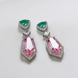 Detail of elegant silver drop earrings with pink and green stones and small zirconia