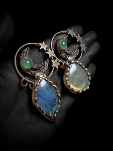 Macro shot of handmade moon and star pendant with labradorite gemstone and green chalcedony