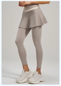 Detail of high-waist criss-cross waistband on beige two-piece yoga leggings skirt