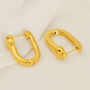 Minimalist gold snake-shaped hoop earrings with red eyes and textured scale details
