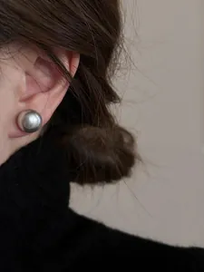 Dettaglio dell'orecchino a perla grigio scuro da 12mm in stile vintage francese su modella