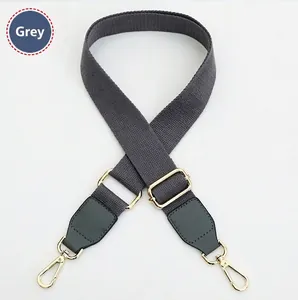 Detail of adjustable gray polyester shoulder strap with golden metal lobster clasps