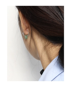 Detail of silver S925 sterling silver hoop earrings with green jade pendant on model