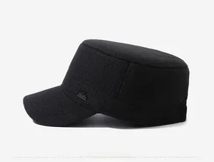 Detail of black winter flat top army cap with herringbone wool texture and metal logo