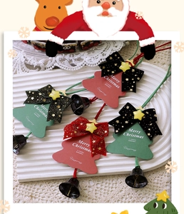 Detail of red and green Christmas tree ornaments with bows, stars and black metal bells