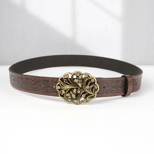 Detail of vintage metal buckle with bee and rhinestone on embossed leather belt