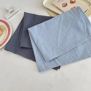 Macro view of blue solid color heat-resistant fabric placemats showing fine woven texture.