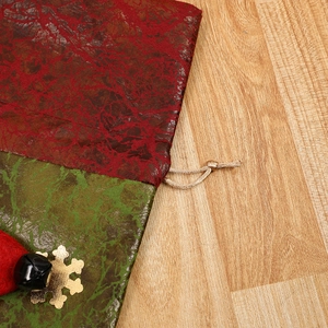 Sacchetto regalo di Natale con trama marmorizzata rossa e verde, fiocco d'oro e campanello