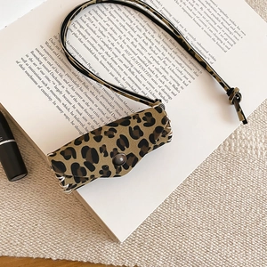 Detail of leopard print leather bag necklace with metal snap button and stitching