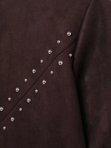 Detail aus burgunderrotem Wildlederimitat mit diagonalen silbernen Metallnieten