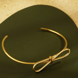 Elegant gold bow-knot open bangle for women with a minimalist polished metal wire design