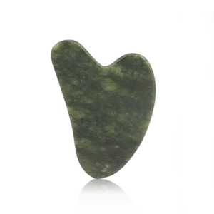 Detailed view of heart-shaped dark green resin gua sha tool with natural texture and reflection