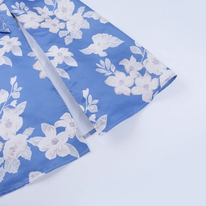 Close-up of side slit detail on blue floral print backless summer dress fabric