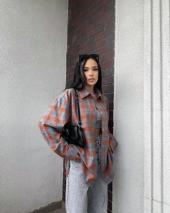 Close-up of vintage grey and orange plaid shirt with soft flannel texture and buttons