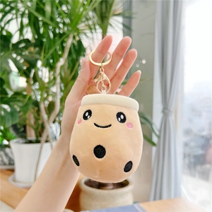 Close-up of a cute bubble tea plush keychain with smiling face and golden metal ring
